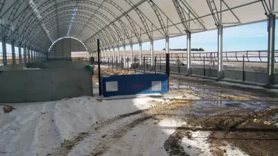 Livestock hoop barn with ridge vent and feed awnings on both sides