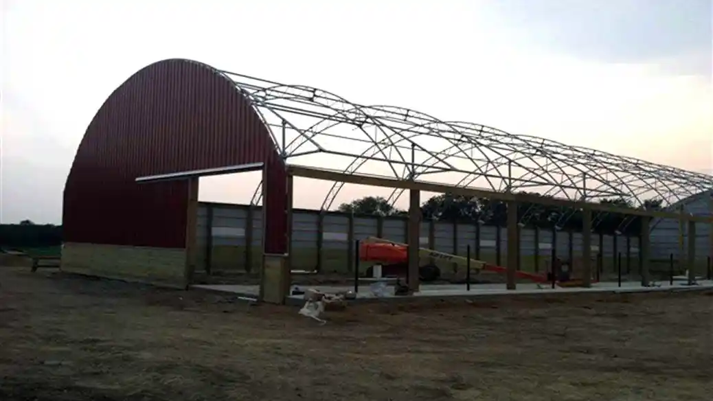 Double pipe truss building being built from barn kit