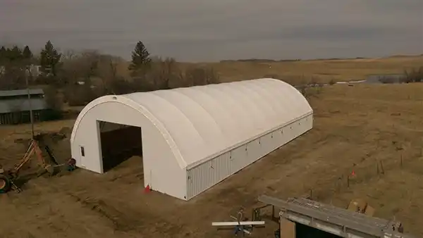 80' wide hoop building at the edge of a field