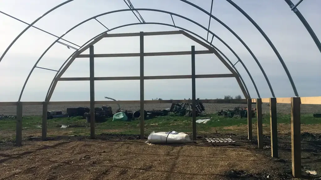 Framing for a tin end wall on a hoop barn