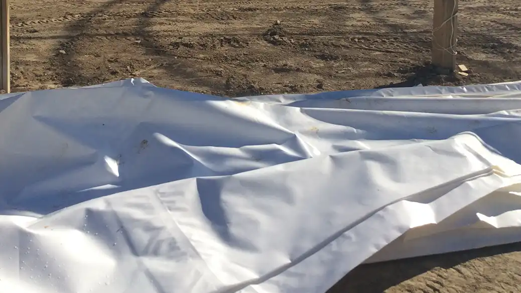 Unfolding a new replacement cover to install tie down pipes