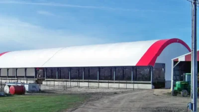 Truss hoop livestock barn with feed awning