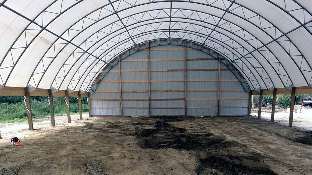 Low profile truss dairy cow hoop shed